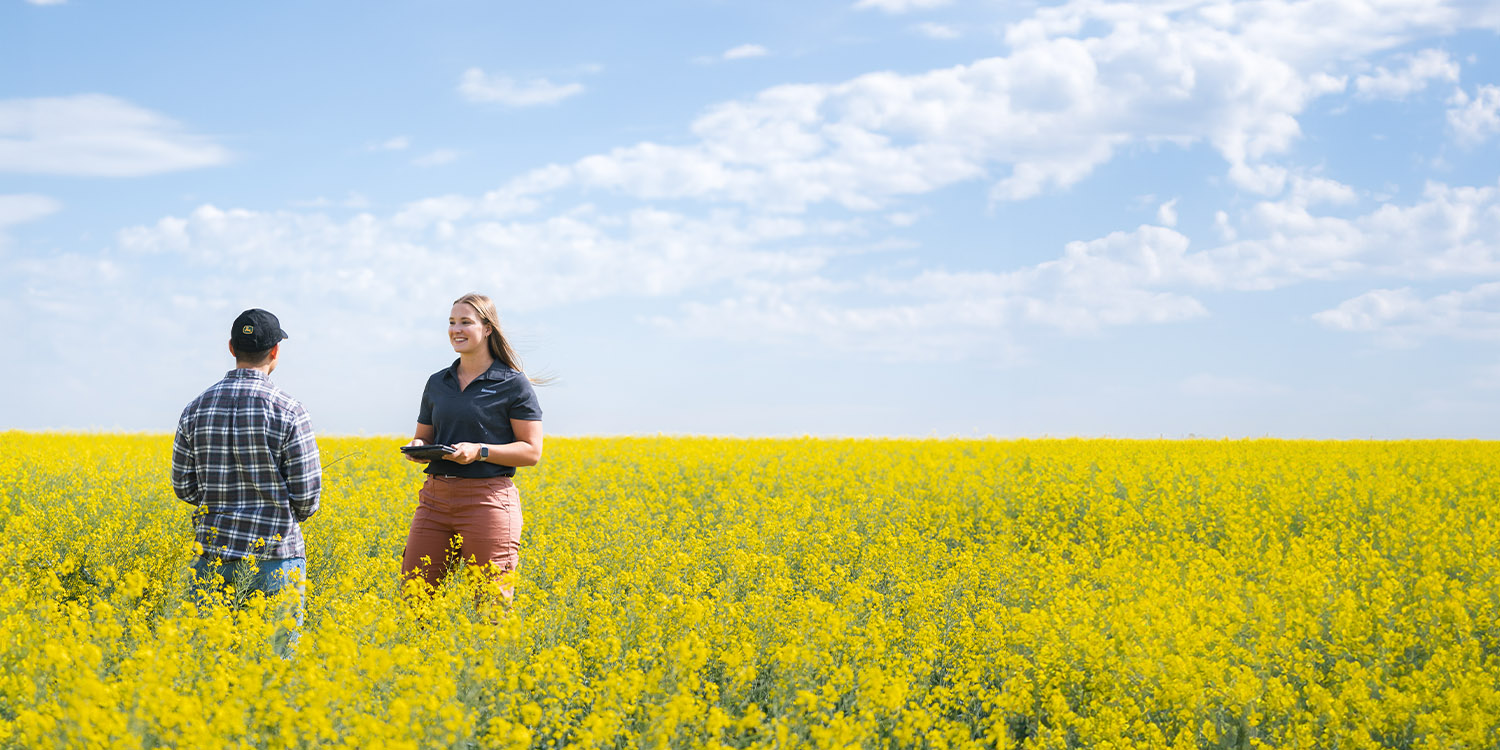 Richardson Pioneer Employee with Grower in Canola Field